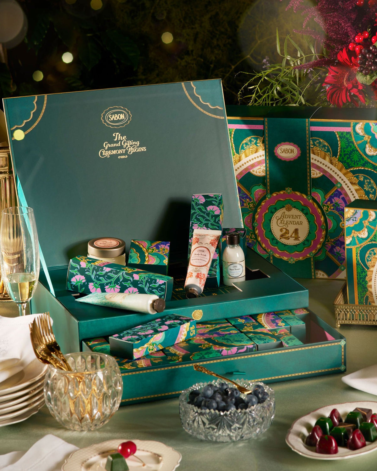 Luxury gift set with decorative boxes and items on a table with a festive background.
