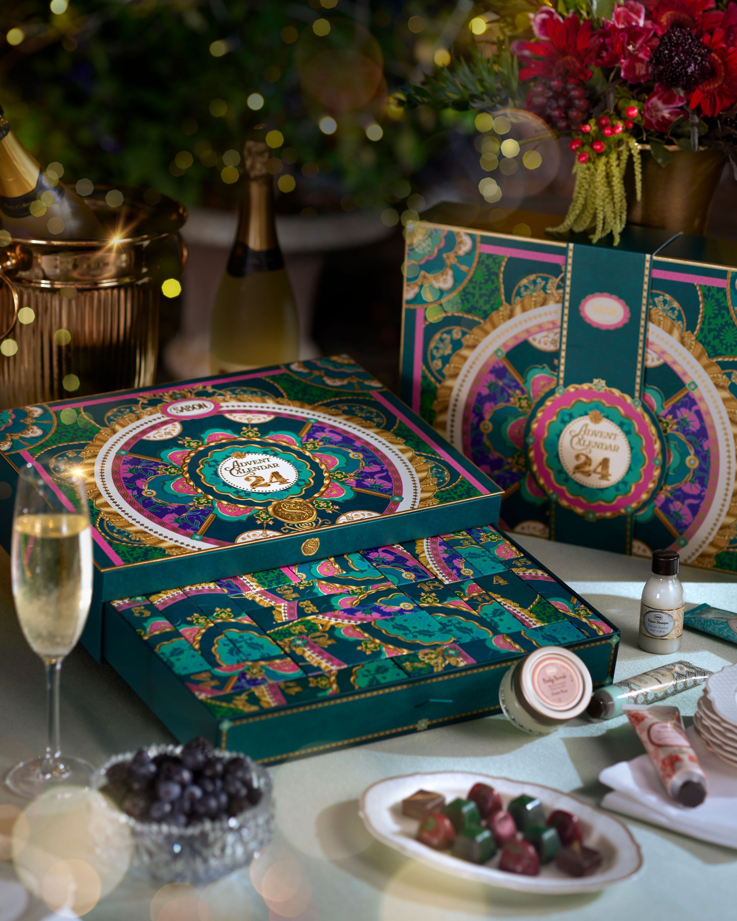 Decorative advent calendar with festive design on a table with champagne and snacks.