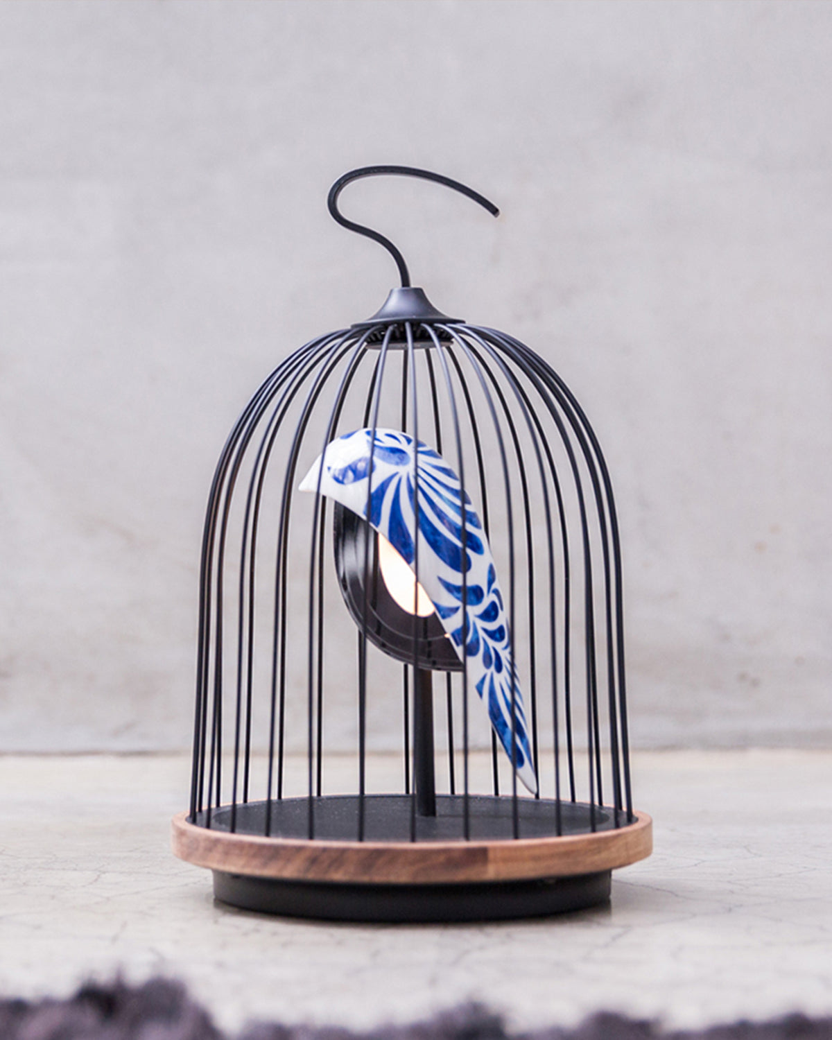 Daqi Bluetooth Speaker and Light white porcelain bird with navy Daqi Blue feather pattern gold accents black cage and walnut color speaker base